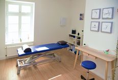  Heller Physiotherapieraum mit Behandlungsliege und Physiotherapie Equipment. 